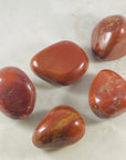 Red Jasper palm stone by Sarah Belle with healing energy and strengthening properties.