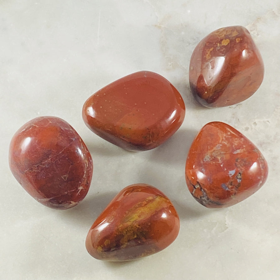 Red Jasper palm stone by Sarah Belle with healing energy and strengthening properties.